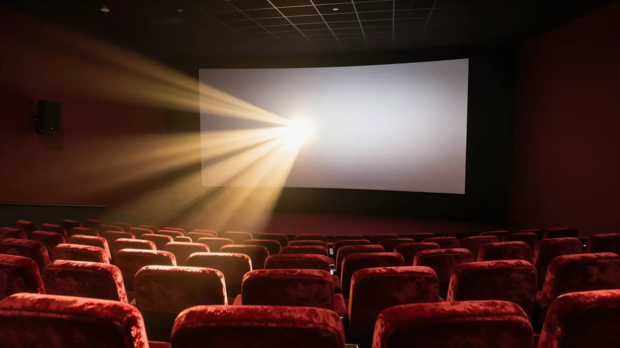 صالة سينما أنيقة بمقاعد حمراء وشاشة عرض كبيرة تجسّد عالم الأفلام وفنّ السينما